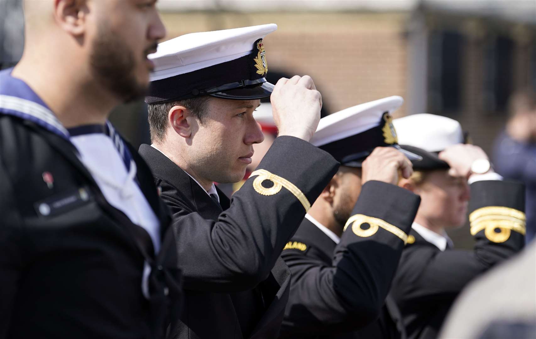 Members of the Royal New Zealand Navy replace their caps during an Anzac Day service of remembrance on board HMS M.33 (Andrew Matthews/PA)